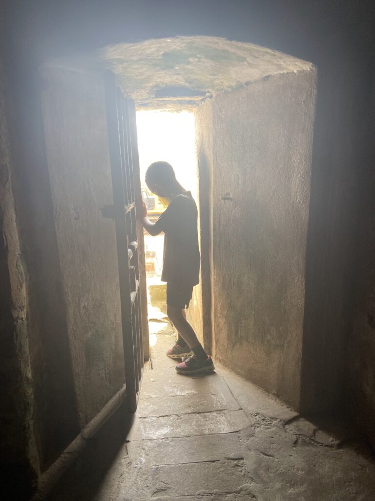 Isaiah stands silohuetted at the Door of No Return at Elmina Castle, Ghana